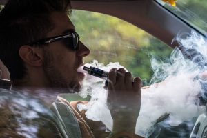 A guy vaping in his car