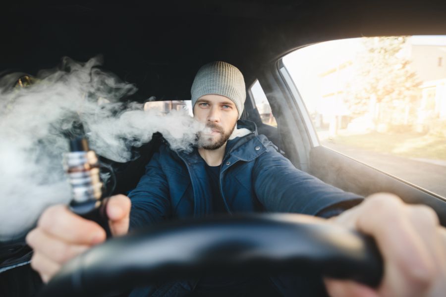 Man vaping while holding a steering wheel